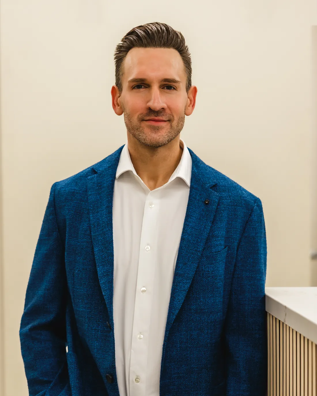 Michael Christopher, MD, standing in a navy jacket and white shirt.